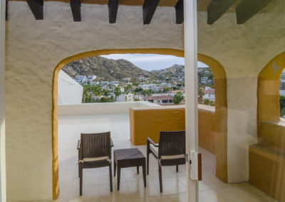 A balcony with three chairs and a table