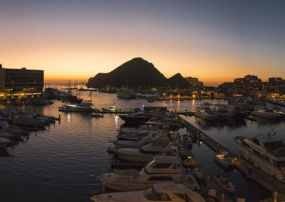 A marina with boats and a mountain in the background.