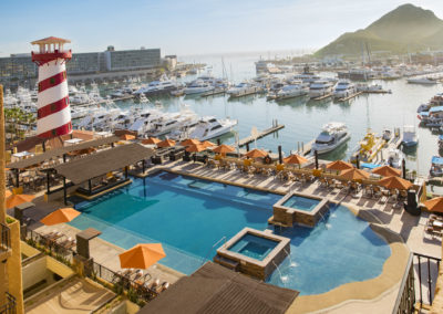 A pool with an ocean view and boats in the water.