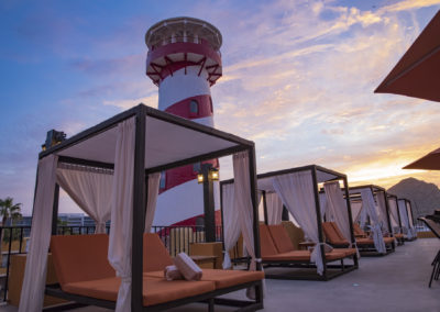 A group of cabanas next to a lighthouse.