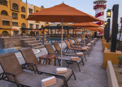 A pool with many chairs and umbrellas