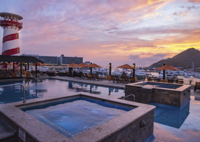 A pool with an ocean view at sunset.