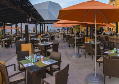 A restaurant with tables and chairs, umbrellas